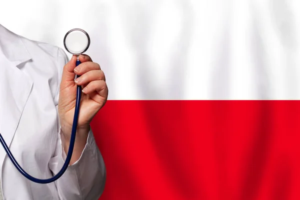 ポーランドの医療従事者の手はポーランドの背景の旗の上に聴診器で — ストック写真