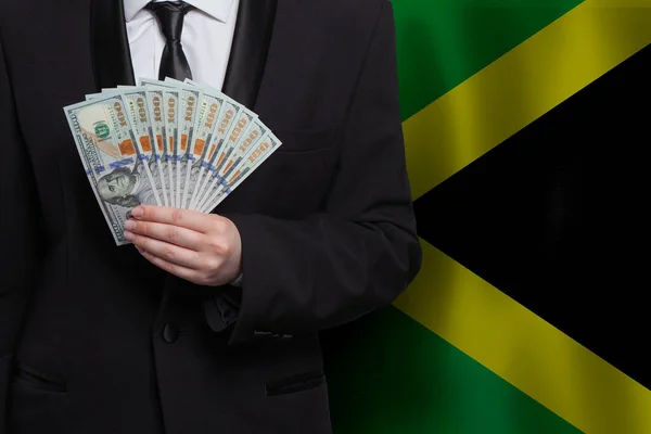 Biznesmen Trzyma 100 Dolarów Amerykańskich Banknotów Tle Flagi Jamajki — Zdjęcie stockowe