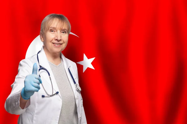 Turca Sonriente Madura Médico Mujer Sosteniendo Estetoscopio Bandera Turquía Fondo —  Fotos de Stock