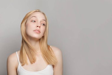 Beyaz arka planda poz veren güzel sarışın kadın.