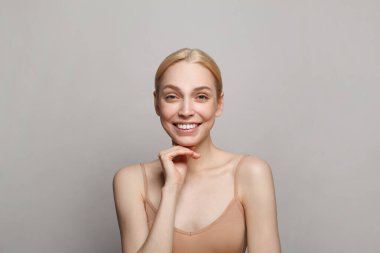 Neşeli bayan model stüdyo portresi. Yüz bakımı, kozmetoloji, cilt bakımı, hidrasyon, hijyen ve güzellik konsepti