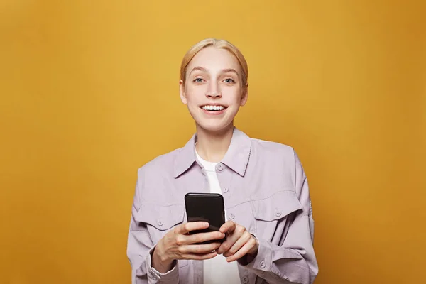 Attraktive Model Frau Mit Blonden Haaren Mit Smartphone Auf Leuchtend — Stockfoto