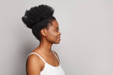 Güzel bir kadın model profili. Çekici bir kadın yüzü, beyaz stüdyo duvarında temiz bir ten var.