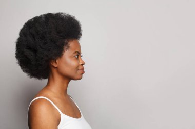 Beyaz stüdyo duvarında taze cildi olan genç ve güzel bir kadın.