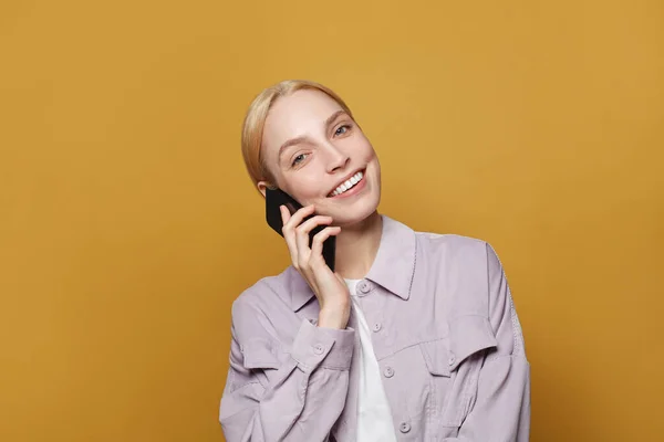 Weibliches Modelltelefon Hübsche Frau Hält Handy Auf Leuchtend Gelbem Studiowand — Stockfoto