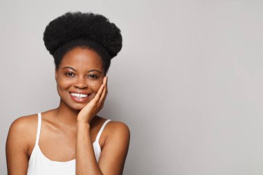 Young beautiful cheerful woman touching her hand her fresh clean skin on white studio wall background. Beauty, facial treatment, skin care concept