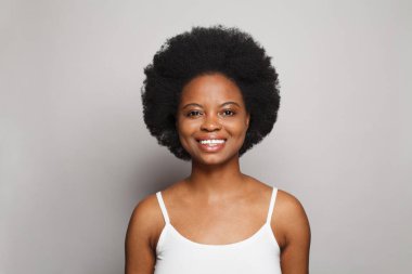Portrait of beauty cheerful woman model with healthy clean skin smiling on white studio wall background