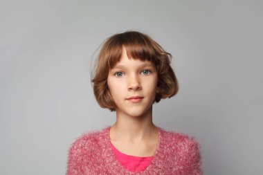 Studio portrait of cheerful 8 years old child girl. Cute girl in pink clothes
