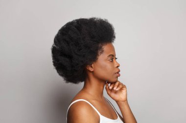 Beautiful female profile on light studio wall background