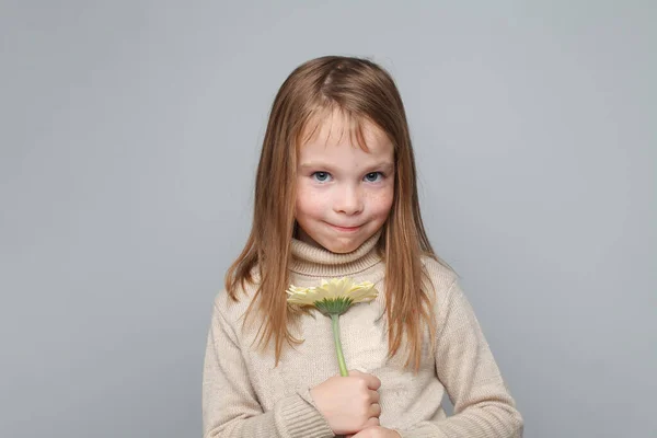 Mischievous child girl with flower, portrait