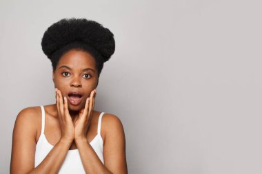 Shocked beautiful woman brunette with opened mouth looking at camera. Isolated closeup portrait on white background with copy space