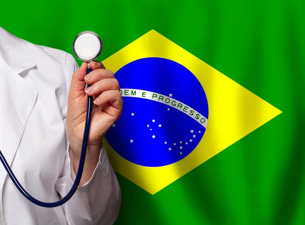 Brazilian doctor\'s hand with stethoscope on the background of flag of Brazil Medicine, clinic, practitioner, healthcare