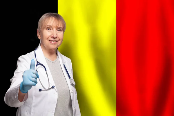 比利时面带微笑的成熟女医生 手持比利时国旗的听诊器 — 图库照片