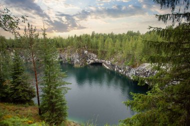 Muhteşem bulutlu gökyüzü, yeşil ağaçlar ve dağ nehri