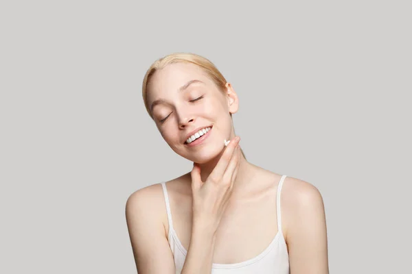 Glückliche Schöne Frau Lächelt Und Trägt Weiße Feuchtigkeitscreme Auf Ihre — Stockfoto