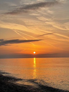 Deniz, sahil, gökyüzü ve güneş. Tropik sahil manzarasına ilham ver. Turuncu ve altın gün batımı gökyüzü