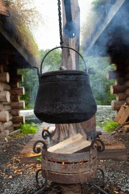 Kaputa demir kazan dökmek, doğada yemek yapmak.