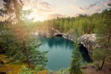 Güneş doğarken muhteşem manzara, bulutlu gökyüzü, yeşil ağaçlar ve dağ nehri