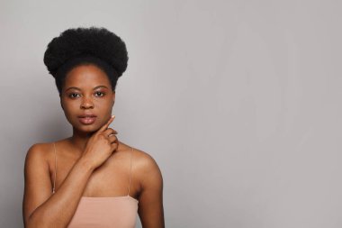 Güzel, genç bir bayan yüzü. Gri arka planda temiz, koyu tenli, güzel bir spa modeli kadın esmer. Cilt bakımı, kozmetoloji ve yüz tedavisi kavramı