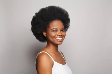 Sağlıklı, mutlu model kadın esmerin portresi. Gri arka planda temiz, koyu tenli. Cilt bakımı ve yüz tedavisi kavramı