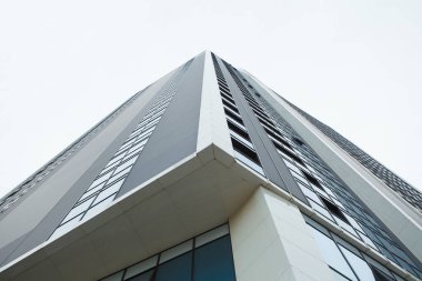 Beyaz gökyüzünün arka planında çelikten ve camdan oluşan fütürist bir gökyüzü.