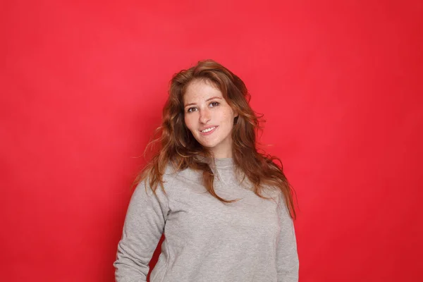 Aantrekkelijke Brunette Vrouw Grijze Trui Rode Studio Muur Achtergrond — Stockfoto