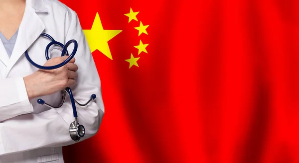 Chinese medicine and healthcare concept. Doctor close up against flag of China background
