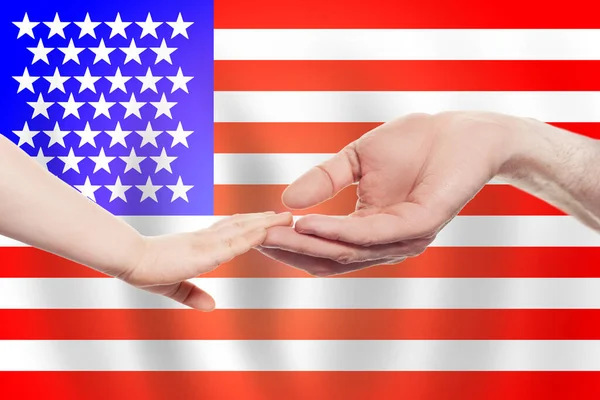 以美国国旗为背景的美国婴儿和父母的手帮助 慈善概念 — 图库照片