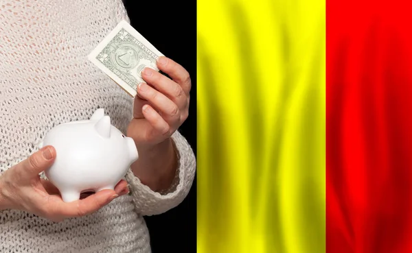 ベルギーの国旗を背景にマネーバンクを持つベルギー人女性 年金基金 退職の概念 — ストック写真