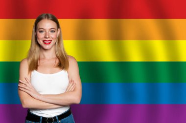 Lgbt bayrağının arkasında gülümseyen güzel, mutlu bir kadın. Özgürlük, destek, hak kavramı