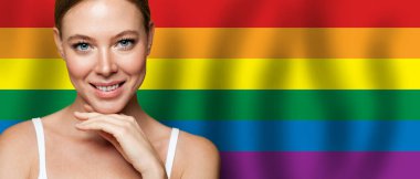 Lgbt bayrağının arkasında gülümseyen güzel bir kadın. Özgürlük, destek, hak kavramı
