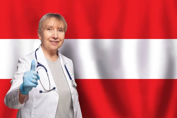 Avusturyalı Gülümseyen Olgun Doktor Kadın Avusturya Bayrağında Steteskop Taşıyor — Stok fotoğraf