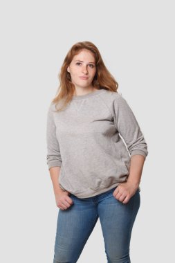 Başarılı, orta yaşlı bir kadın beyaz stüdyo portresinin üzerinde duruyor.