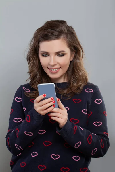 Glückliche Frau Mit Smadrtphone Sms Und Lächeln Auf Grauem Hintergrund — Stockfoto
