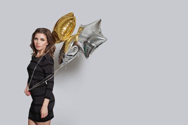 Fotokopi alanı olan gri afiş üzerinde balon tutan genç bir kadın.