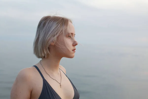 stock image Portrait of young woman teenager girl 17 years old standing on romantic background of beautiful blue sea and cloudy sky