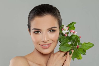 Güzel, gülümseyen esmer, sağlıklı, taze tenli stüdyo portresi olan bir kadın.