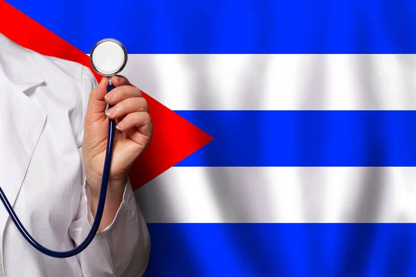 キューバ医学 診療所 開業医 医療の旗の背景に聴診器を持つキューバの医師の手 — ストック写真