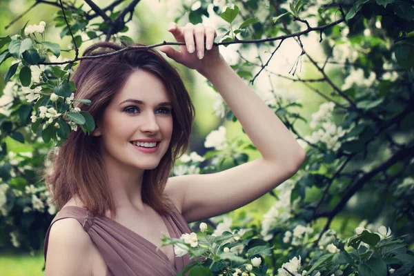 Dışarıdaki Çiçeklerle Gülümseyen Genç Kadın — Stok fotoğraf