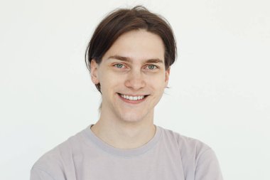 Genç adam gülümsüyor, beyaz arka planda stüdyo resmi var.