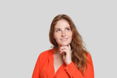 Oldukça düşünceli bir kadın beyaz arka plana bakıp düşünüyor. Şüphe ve fikir kavramı