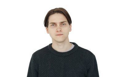 Düşünceli genç esmer adam beyaz arka planda izole edilmiş kameraya bakıyor.