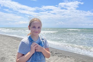 Denizde mutlu bir çocuk. Çocuk dışarıda gülümsüyor. Yaz tatili ve sağlıklı yaşam tarzı konsepti