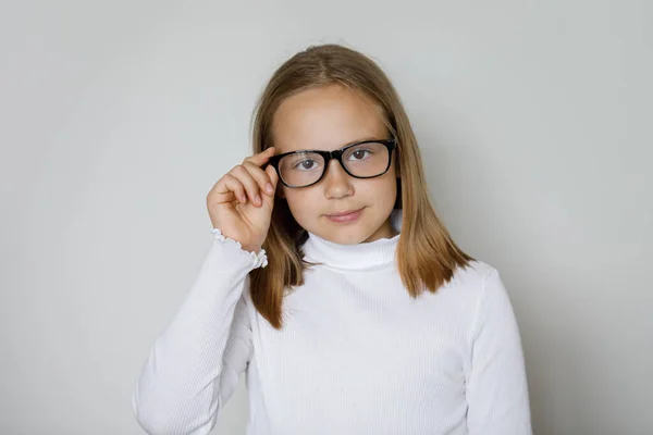 白い壁の背景 スタジオの肖像画のカメラを見ている眼鏡のかなりスマートな若いブルネットの少女 — ストック写真