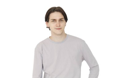 Mutlu genç adam beyaz arka planda izole edilmiş kameraya bakarak düşünüyor.