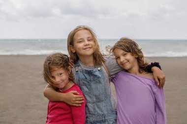 Çekici, sevimli, dışarıda kucaklaşan kız çocukları. 7, 8 ve 10 yaşındaki çocuk portresi