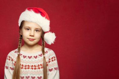 Neşeli sevimli kız çocuğu, Noel portresi. Mutlu çocuk Noel Baba, renkli kırmızı arka plan
