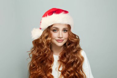 Uzun dalgalı kızıl saçlı ve sağlıklı ciltli bir Noel kadını. Güzel kadın Noel Baba portresi