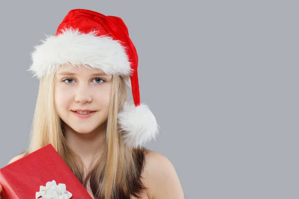 Gülümseyen Noel Baba Şapkalı Genç Kız Gri Arka Planda Kırmızı — Stok fotoğraf