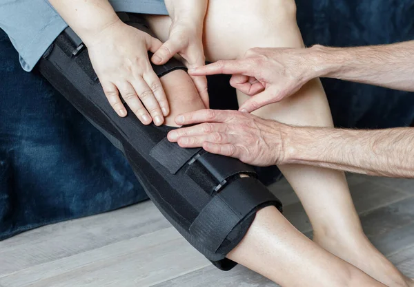 Rehabilitation concept. Man therapist or knee brace in physiotherapy with woman patient, knee pain or consulting expert. Physiotherapist, physical therapy and healthcare worker help, support or advice